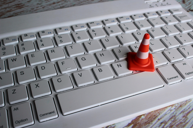 a laptop keyboard with a construction cone on top representing website maintenance